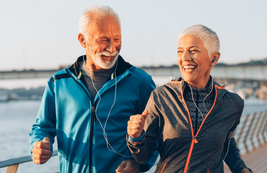 ein joggendes Paar in den sechzigern am Fluss - vielleicht auf dem Weg zum Lauflabor von o.t.n